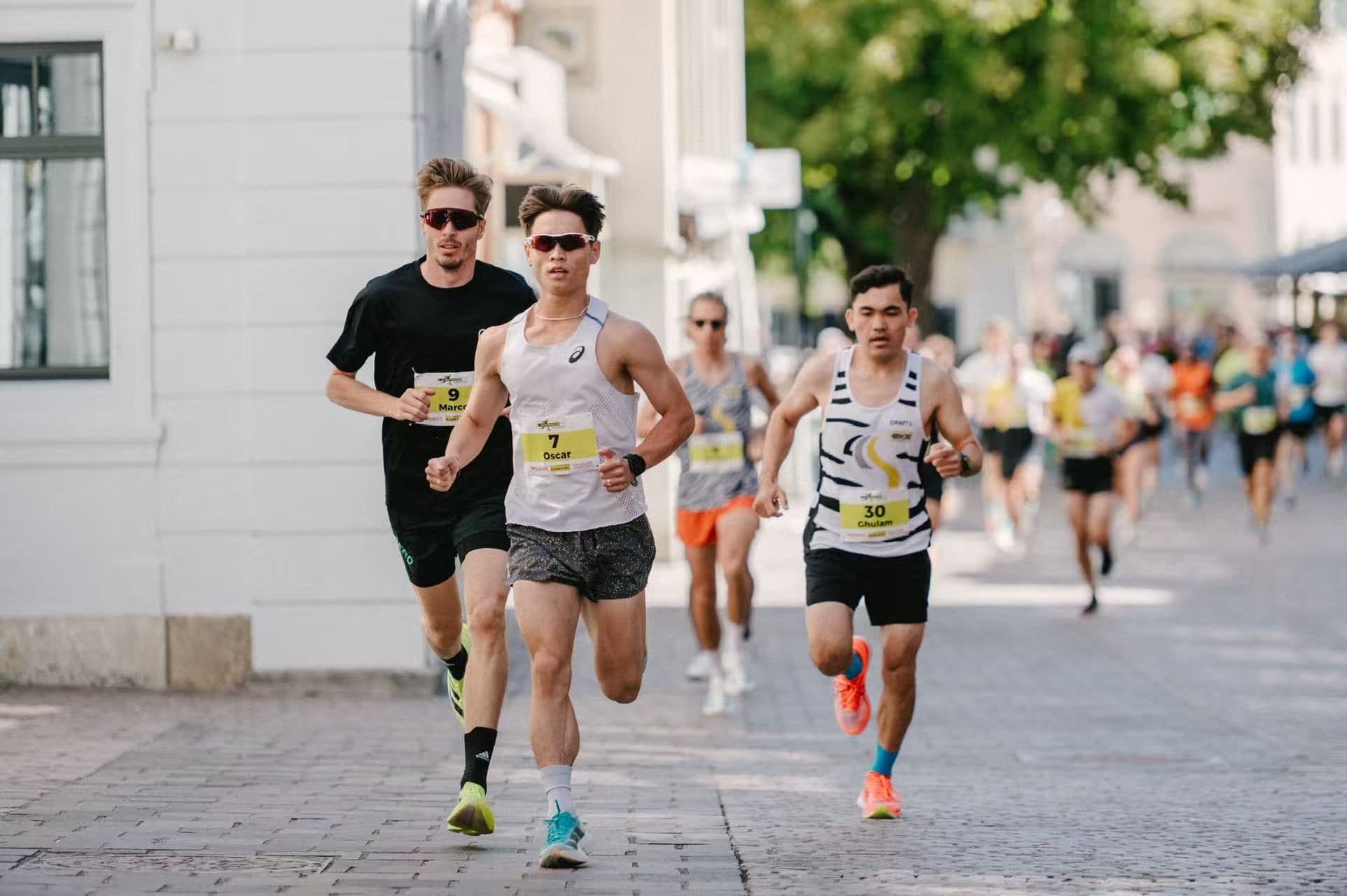 Oscar, wearing bib 7, leading a group of runners through town